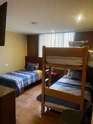 a bedroom with two bunk beds and a flat screen tv at Matty House in Lima