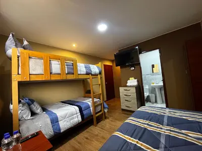 a bedroom with two bunk beds and a bathroom at Matty House in Lima