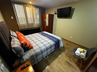 a small bedroom with a bed and a television at Matty House in Lima