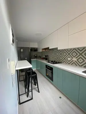 a kitchen with blue and white cabinets and a table at Vistamar Duplex in Lima