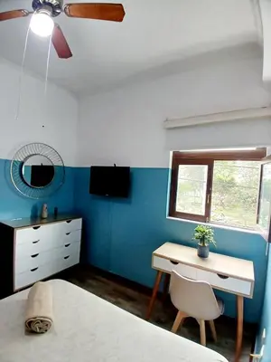 a bedroom with a bed and a desk and a window at Miraflores Kennedy Park in Lima