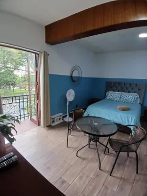 a bedroom with a bed and a table and a balcony at Miraflores Kennedy Park in Lima