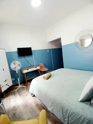a bedroom with a bed and a desk and a television at Miraflores Kennedy Park in Lima