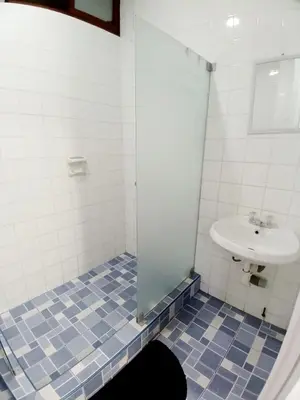 a bathroom with a sink and a glass shower door at Miraflores Kennedy Park in Lima