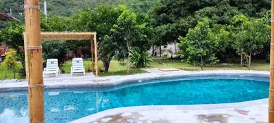 a swimming pool with two chairs and a gazebo at Pampa Bella Lodge in La Merced