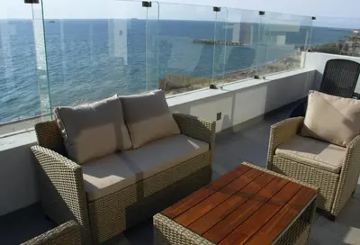 a balcony with a couch and chairs and a table at Suite 1 Fila Vista Bahía Paracas- La Velas 601 T1 in Paracas