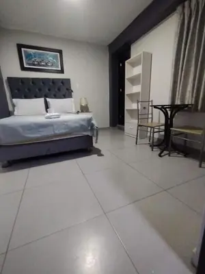 a bedroom with a bed and a table in it at Hostal El Edén Huaral in Huaral