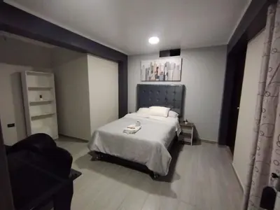 a bedroom with a bed and a chair in it at Hostal El Edén Huaral in Huaral