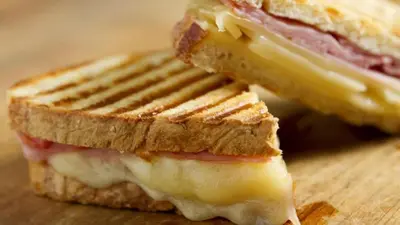 a sandwich with meat and cheese on a cutting board at Serenzza Hotel in Lima