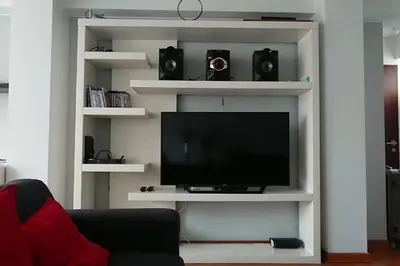 a white entertainment center with a flat screen tv at Elegante Flat en inmejorable ubicación - San Isidro in Lima