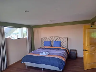 a bedroom with a bed with a stuffed animal on it at Maychu's Albergue in Chinchero