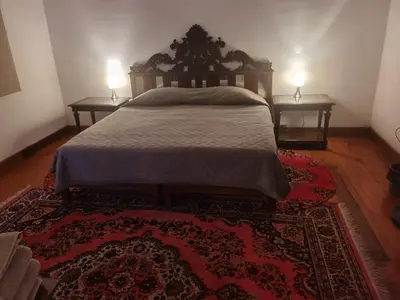 a bedroom with a bed with two nightstands and a rug at La Casona Hospedaje in Lima