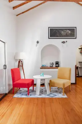 a living room with two chairs and a table at Andenes in Cusco