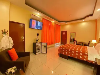 a hotel room with a bed and a tv at Hotel Las Palmeras in Huacho
