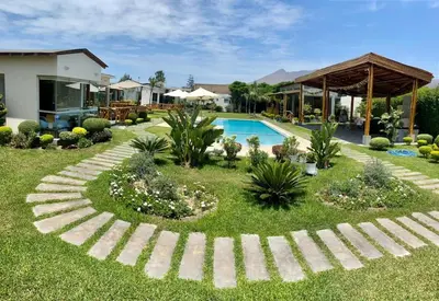 a garden with a swimming pool and a house at Kuyayky Lodge in Lima