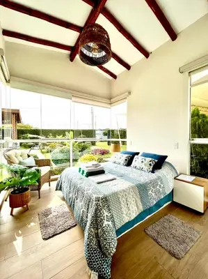 a bedroom with a bed and large windows at Kuyayky Lodge in Lima