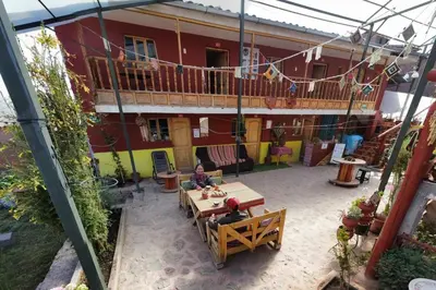 two people sitting at a table in front of a building at KanchayKillaWasi in Chinchero