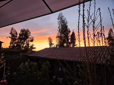 a sunset view of a house with a roof at KanchayKillaWasi in Chinchero