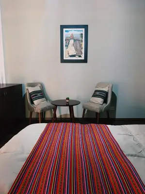 a bedroom with a bed and two chairs and a table at Hotel Vista Verde in Huancayo