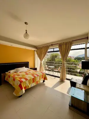 a bedroom with a bed and a large window at Hotel Rumi Wasi in Lunahuaná