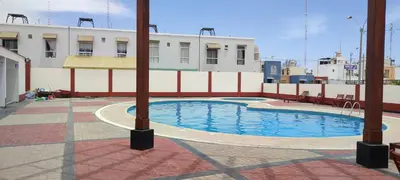 a swimming pool on the side of a building at Casa Club Vacacional in Ica