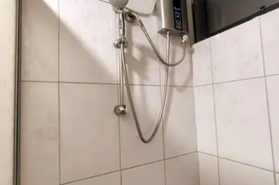 a shower with a hose in a bathroom at Depawanka 1 departamento amoblado in Huancayo