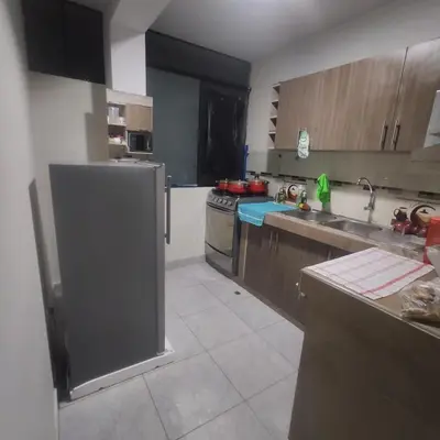 a kitchen with stainless steel appliances and wooden cabinets at Depawanka 1 departamento amoblado in Huancayo
