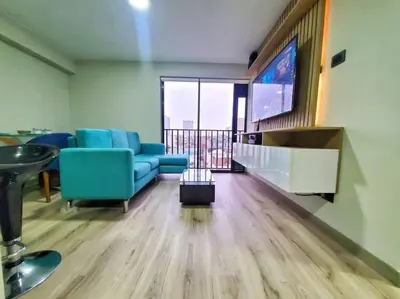 a living room with blue chairs and a flat screen tv at Apartamento estreno céntrico y moderno in Lima