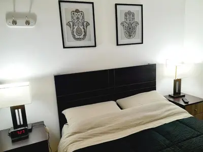a bedroom with a bed and two lamps and pictures on the wall at Stylish New Apartment with stunning Ocean View near Miraflores in Lima