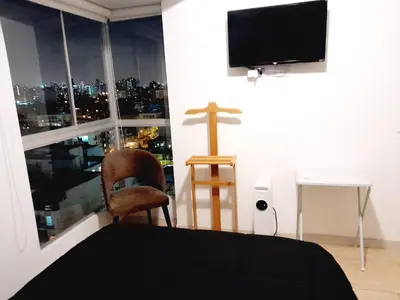 a bedroom with a cross on the wall next to a window at Stylish New Apartment with stunning Ocean View near Miraflores in Lima