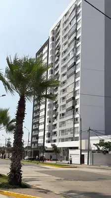 a palm tree in front of a tall building at Stylish New Apartment with stunning Ocean View near Miraflores in Lima
