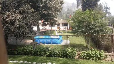 a fence with a pool in a yard at casa campestre marina in Chaclacayo