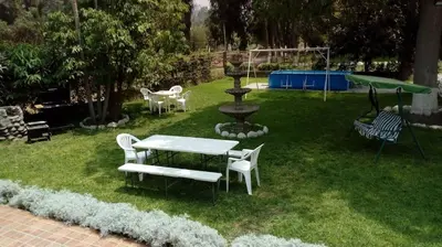 a yard with a table and chairs and a fountain at casa campestre marina in Chaclacayo