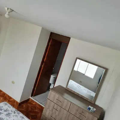 a room with a mirror and a dresser and a window at Apart Hotel Cabral in Lima