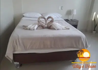 two swans making a heart shape on a bed at Hostel Willys House in Paracas
