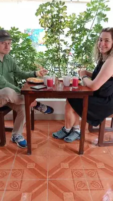 a man and a woman sitting at a table at Hostel Willys House in Paracas