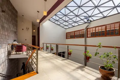 a hallway with a skylight in a building with potted plants at Mamasara Cusco in Cusco
