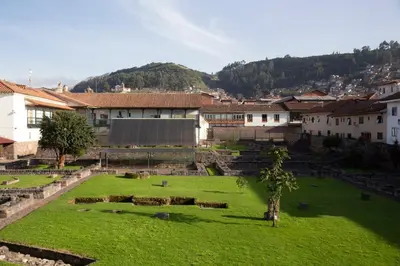 a green field in a town with buildings and trees at Abittare Hotel in Cusco