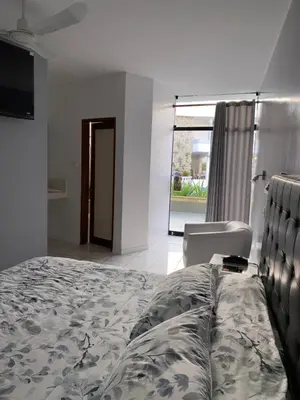 a bedroom with a bed and a chair and a window at Embassy Beach in Pisco