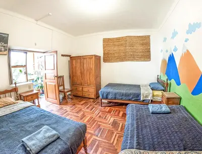 a bedroom with three beds and a wooden floor at Eco Home View - Guest House in Cusco