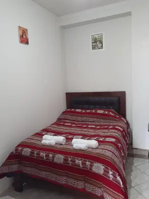 a bedroom with a bed with towels on it at WAYRA APART HOTEL in Cusco