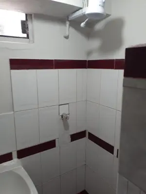 a white bathroom with a toilet and a window at WAYRA APART HOTEL in Cusco