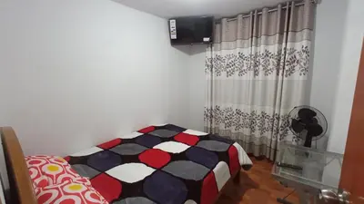 a bedroom with a bed and a curtain at LUANA’S HOUSE in Ica