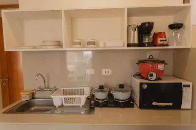 a kitchen counter with a sink and a microwave at Quechua ApartHotel in Cusco