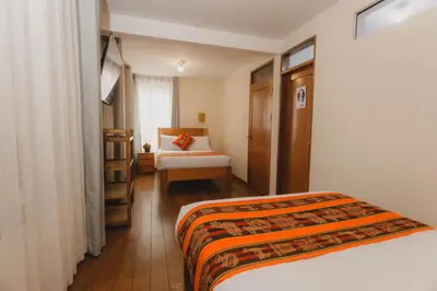 a hotel room with a bed and a chair at Quechua ApartHotel in Cusco