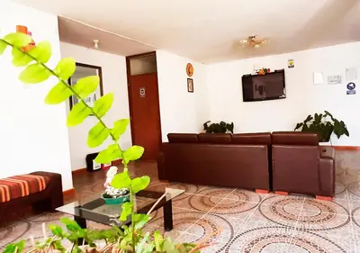 a living room with a couch and a tv at Hotel Viñas del Sol Eterno in Chincha Alta
