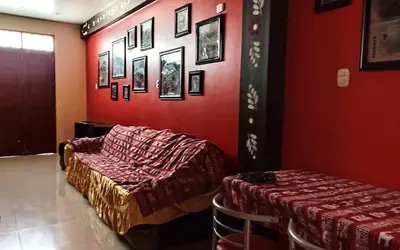 two beds in a room with red walls at Casa Sucre Hostel Ayacucho in Ayacucho