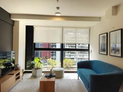 a living room with a blue couch and a large window at Navarrete by Wynwood House in Lima