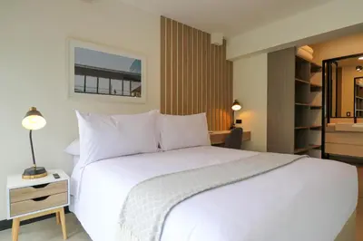 a bedroom with a large white bed and a mirror at Navarrete by Wynwood House in Lima