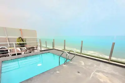 a swimming pool with a view of the ocean at Beautiful apartment Near airport /cozy Oceanfront in Lima